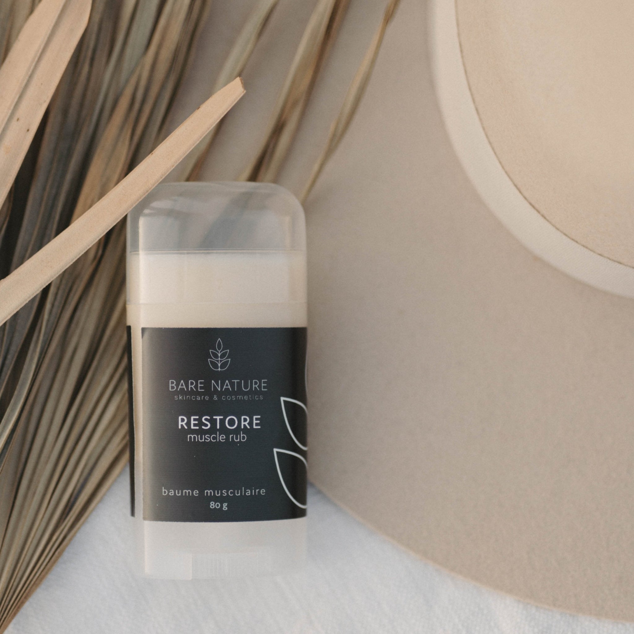 Muscle Rub Product on a background of dry palms and a felt hat.