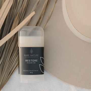 Muscle Rub Product on a background of dry palms and a felt hat. 