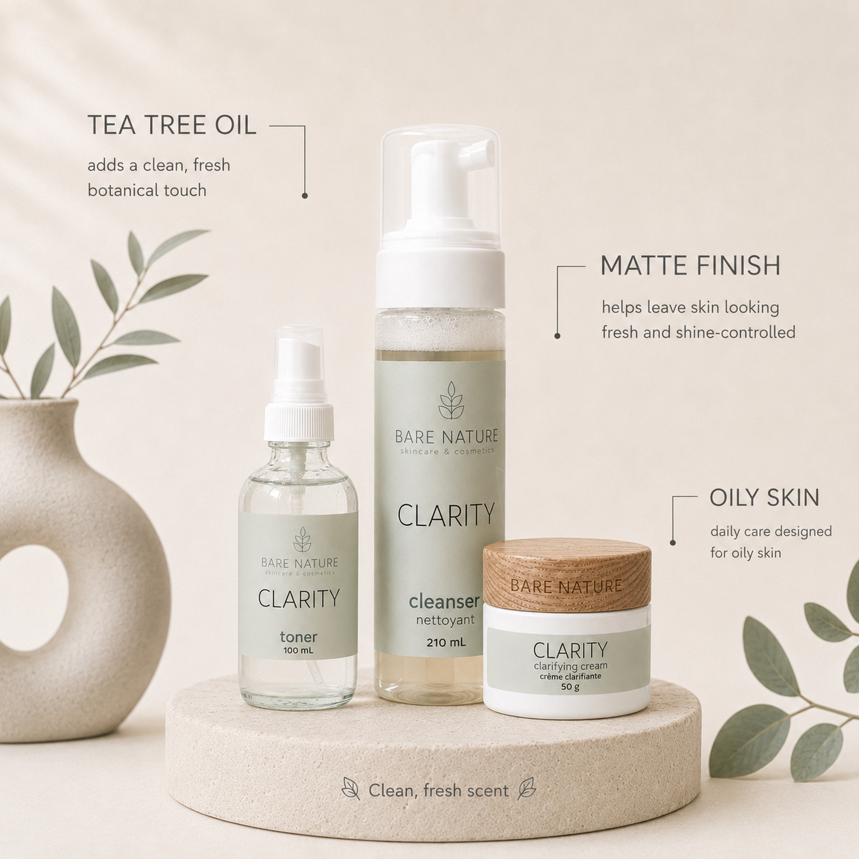 Three Bare Nature skincare Clarity Line products arranged on a round pedestal: a small clear bottle labeled toner, a tall pump bottle labeled cleanser, and a small jar labeled cream, with text callouts describing tea tree oil, matte finish, and oily skin. Decorative leaves and a ceramic vase appear at the sides.