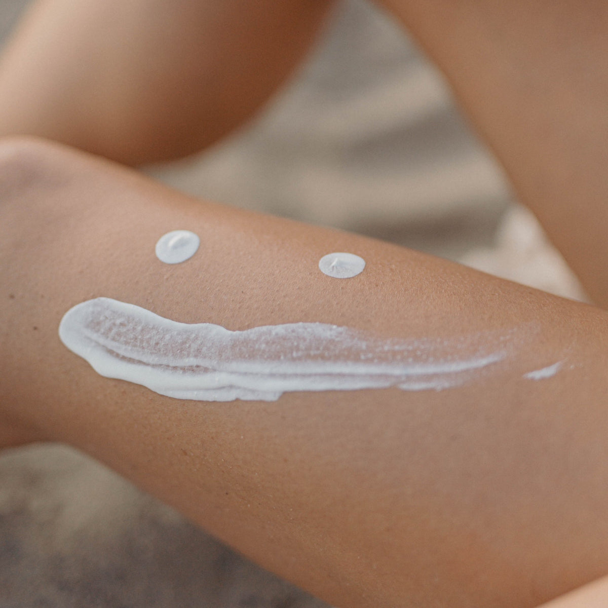 Close-up of a person's leg with Bare Nature Mineral cream swirled on the skin, showing two small dollops above a long textured smear.