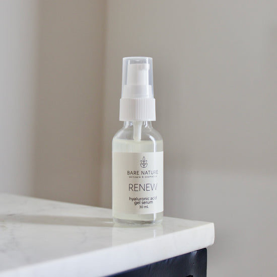 A clear glass jar with a pump dispenser containing the Renew Hyaluronic Acid Gel Serum, placed on a white surface.
